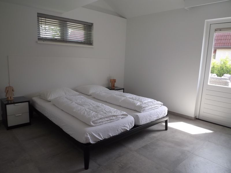 Slaapkamer met tweepersoonsbed in Vakantiehuis Gortersmient 322, De Dennen, Texel, met veel natuurlijk licht.