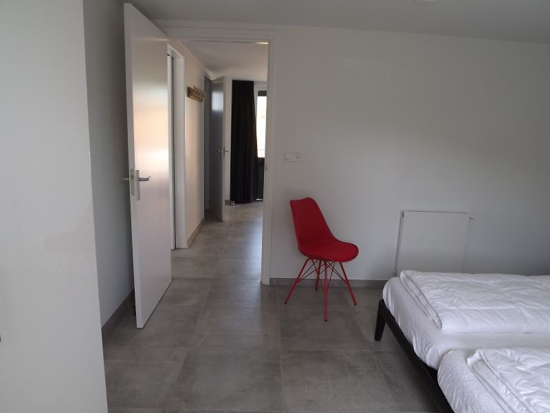 Ruime slaapkamer in Vakantiehuis Gortersmient 322, De Dennen, Texel, met moderne inrichting en toegang tot buiten.