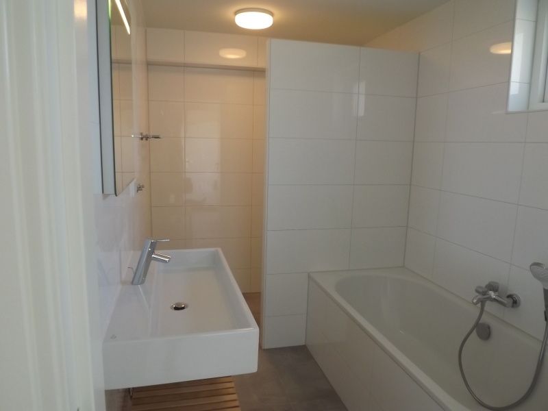 Moderne badkamer met ligbad in Vakantiehuis Gortersmient 322, De Dennen, Texel, voor ultiem comfort.