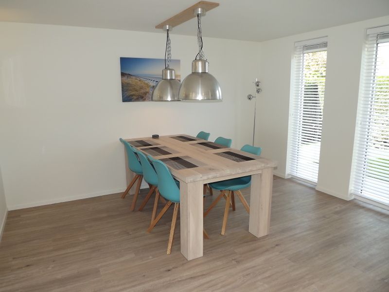 Eetkamer met houten tafel in Vakantiehuis Gortersmient 350, De Dennen, Texel, perfect voor familiediners op de Waddeneilanden.
