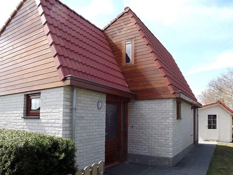 Aussenansicht des Ferienhauses Gortersmient 326 in De Dennen, Texel, mit charmanter Architektur und roten Dachziegeln.