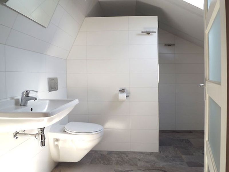 Modernes Badezimmer im Ferienhaus Gortersmient 326, De Dennen, Texel, mit glatten weissen Fliesen und Dusche.
