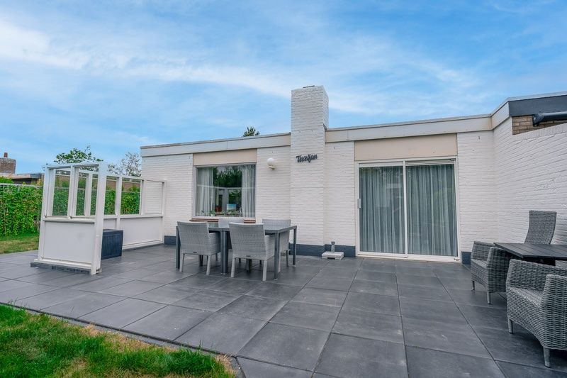 Zonnig terras bij Bungalowpark 't Luwe Land, Texelfan, De Dennen, Texel. Ontspan op het ruime terras van de vakantieaccommodatie.