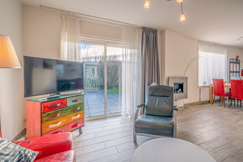 Sfeervolle woonkamer in Bungalowpark 't Luwe Land, Texelfan, De Dennen, Texel. Comfortabele zithoek met toegang tot het terras van het vakantiehuis.