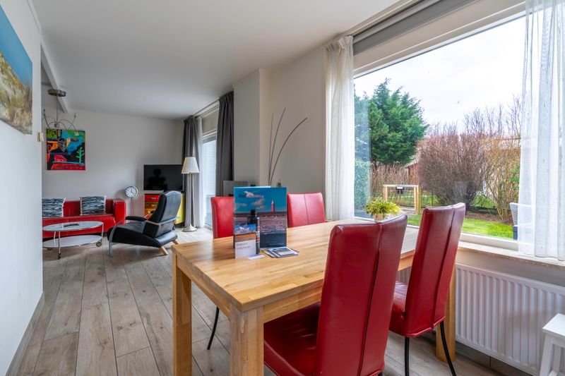 Gezellige eetruimte in Bungalowpark 't Luwe Land, Texelfan, De Dennen, Texel. Eettafel met uitzicht op de tuin in de vakantiewoning.