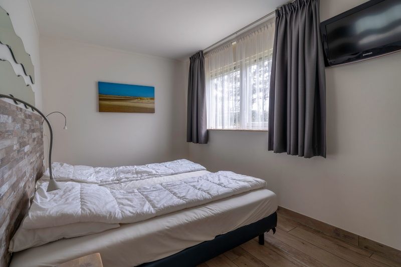 Comfortabele slaapkamer in Bungalowpark 't Luwe Land, Texelfan, De Dennen, Texel. Ruime slaapkamer met natuurlijke lichtinval in de vakantiewoning.