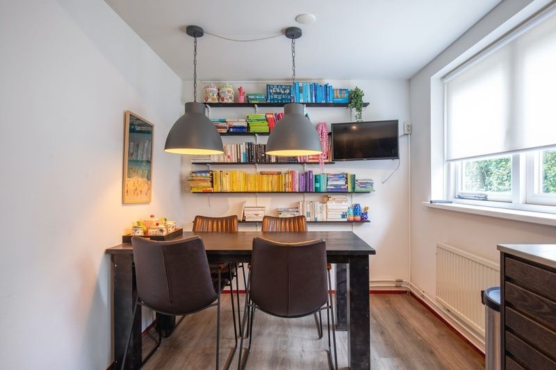 Sfeervolle eetkamer met boekenplanken in Bungalowpark Gortersmient - Blommenzee, De Dennen, Texel.