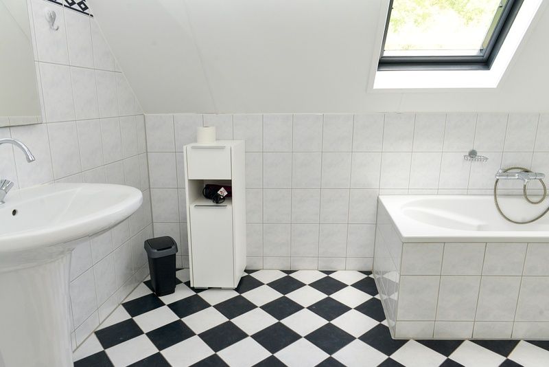 Luxurioeses Badezimmer mit Badewanne im Ferienhaus De Mispel, De Dennen, Texel fuer hoechsten Komfort.