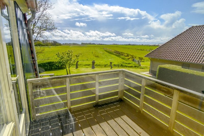 Blick vom Balkon des Ferienhauses De Mispel, De Dennen, Texel auf gruene Felder.