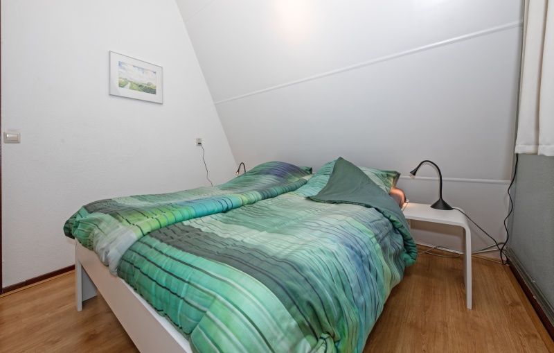Gemuetliches Schlafzimmer mit gruenem Bettzeug im Ferienhaus Gortersmient 236, Bungalowpark Gortersmient, De Dennen Texel.