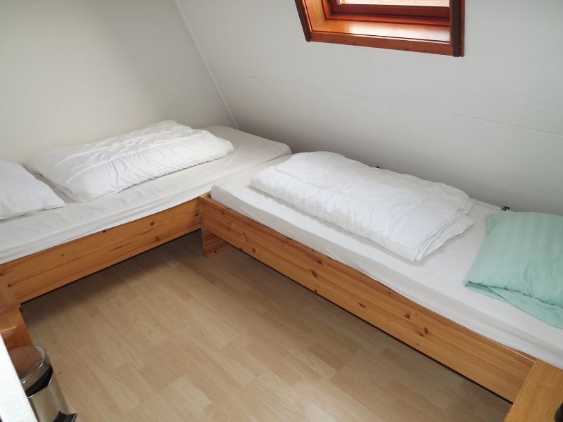 Doppelzimmer mit Holzbetten im Ferienhaus Gortersmient 260, De Dennen, Texel, fuer zusaetzlichen Komfort.