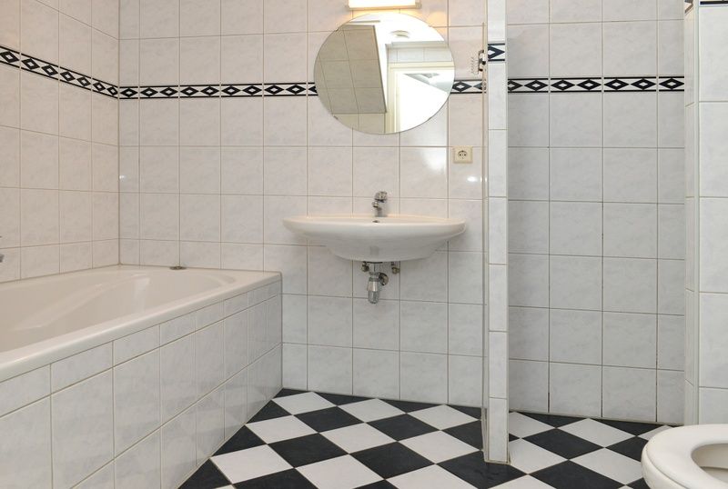 Luxe badkamer met bad en wastafel in vakantiehuis Turel, De Dennen, Texel.