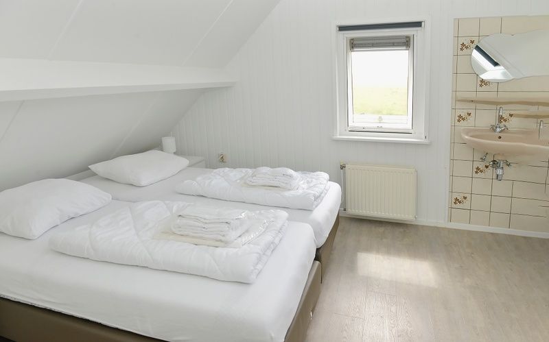 Slaapkamer met tweepersoonsbed in vakantiehuis Turel, De Dennen, Texel.