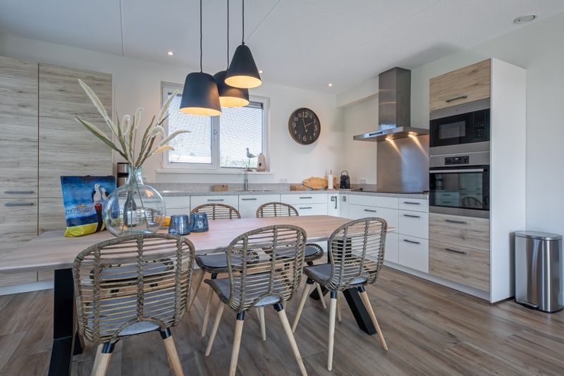 Gezellige eetkamer bij Villa Effe Wad op Bungalowpark 't Hoogelandt, Texel, met houten tafel en design stoelen.