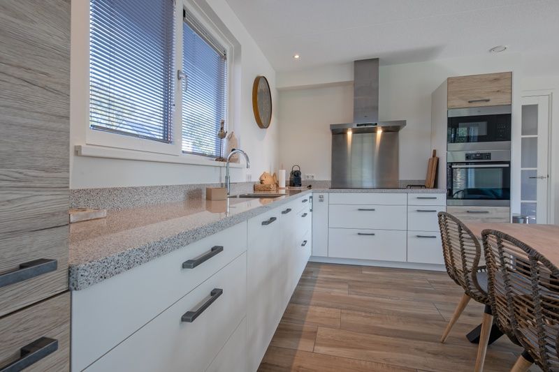 Moderne keuken in Villa Effe Wad, Texel, met strakke afwerking en veel opbergruimte.