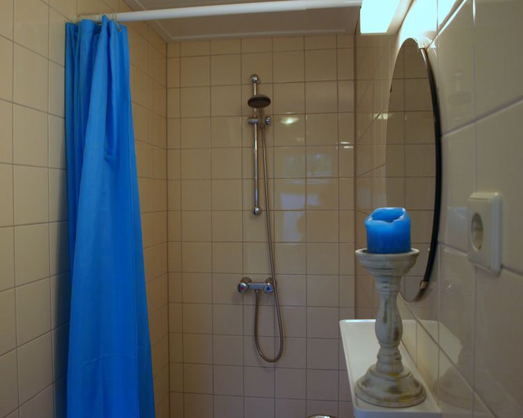 Moderne Dusche im Ferienhaus Duinpieper, De Dennen, Texel mit blauen Akzenten.