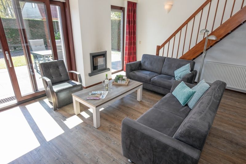 Comfortabele zithoek in Vakantiehuis Gortersmient 328, De Dennen, Texel met uitzicht op de tuin.