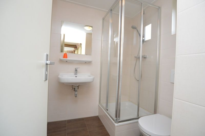 Moderne badkamer in Bungalow Verste Coogh 140, De Dennen, Texel met douchecabine.