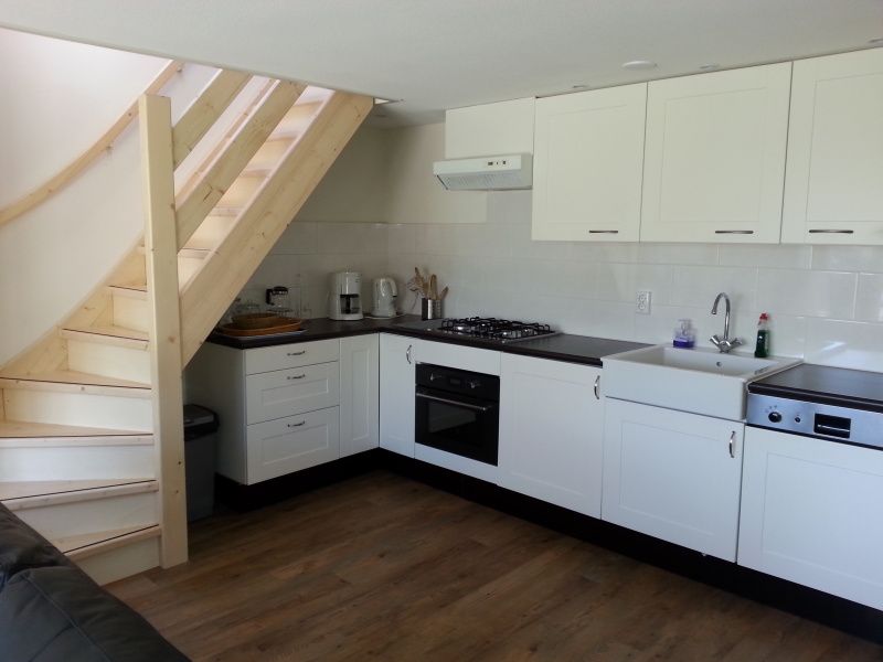 Moderne Kueche im Ferienhaus Bollenveld - de Iris, De Dennen, Texel mit Treppe zum Obergeschoss.