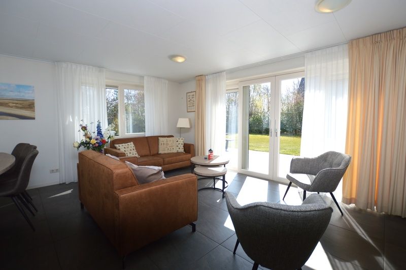 Helles Wohnzimmer des Ferienhauses de Parel 190 in De Dennen, Texel mit gemuetlicher Sitzecke.