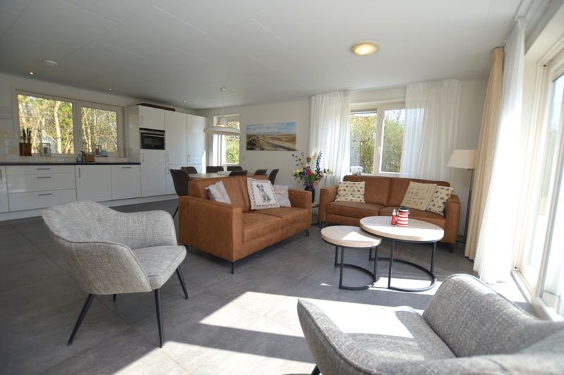 Offenes Wohnzimmer und Kueche im Ferienhaus de Parel 190, De Dennen, Texel mit moderner Einrichtung.