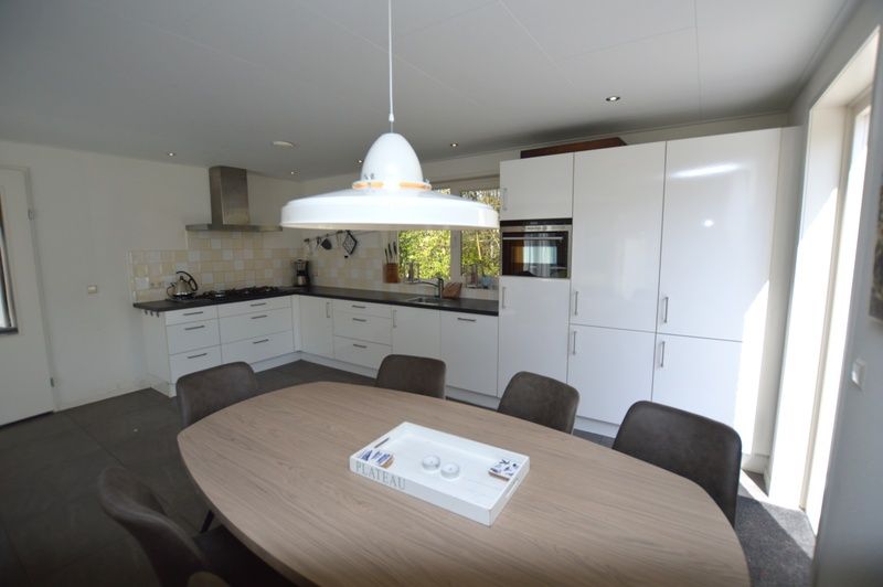 Essecke und Kueche im Ferienhaus de Parel 190, Texel mit Blick auf den Garten.