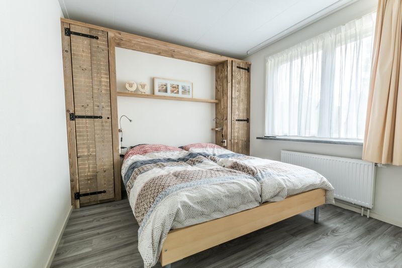 Attraktives Schlafzimmer im Ferienhaus de Parel 190, De Dennen, Texel mit Holzakzenten.