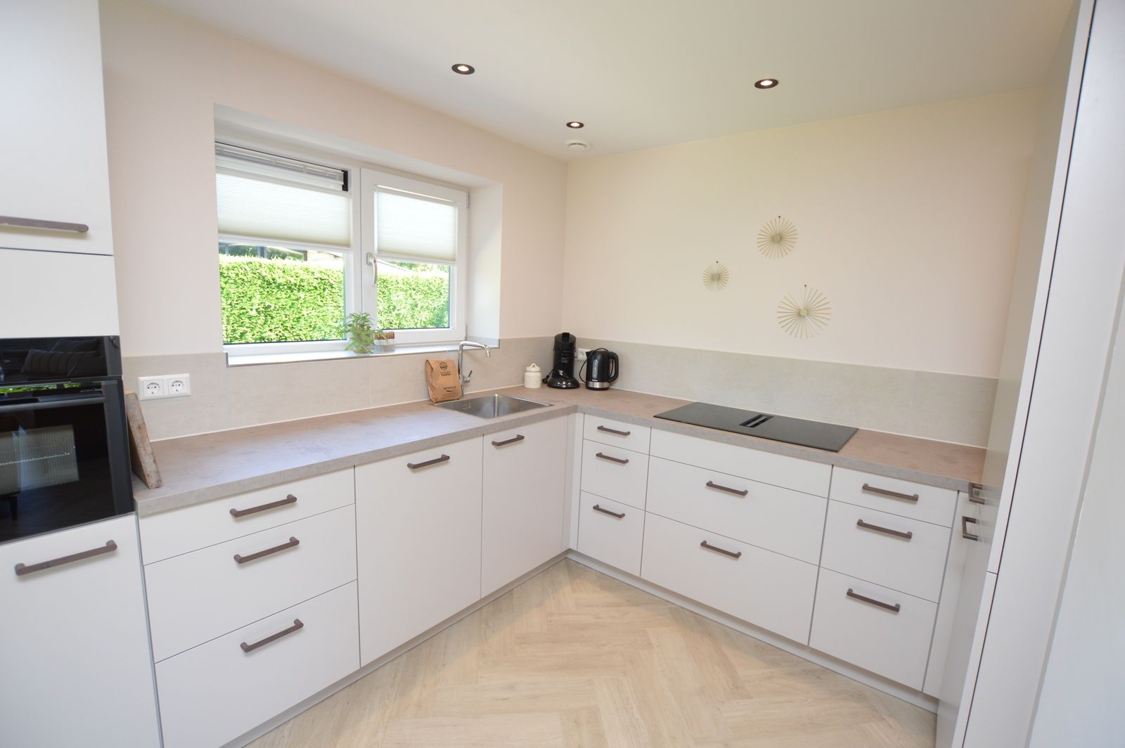 Moderne Kueche im Bungalow 't Hoogelandt 58, Texel, mit schlichter Verarbeitung und viel Stauraum.