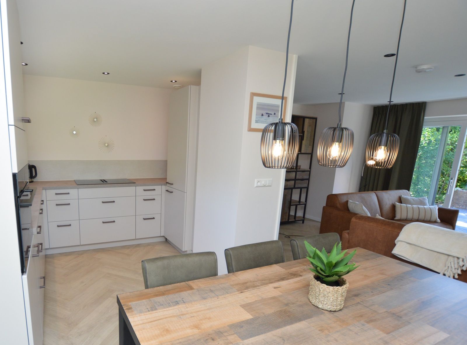 Kueche und Esszimmer im Bungalow 't Hoogelandt 58, Texel, mit moderner Beleuchtung und Moeblierung.