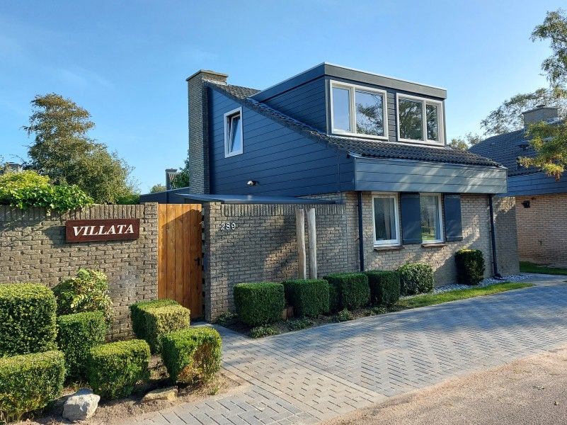 Villata vakantiehuis in De Cocksdorp, Texel met moderne gevel en groene haag.
