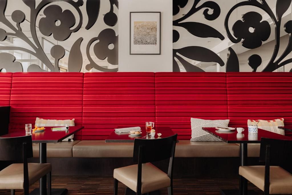 Eetruimte met rode banken in Designhotel Maastricht, vakantieverblijf in Zuid Limburg.
