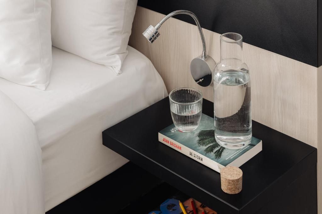 Nachtkastje met boek en water in Designhotel Maastricht, Zuid Limburg, Limburg.