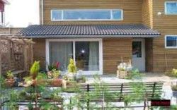 Veranda van De Zandbult in Oost-Vlieland, Vlieland, met groene planten en houten gevel van het appartement op de Waddeneilanden.