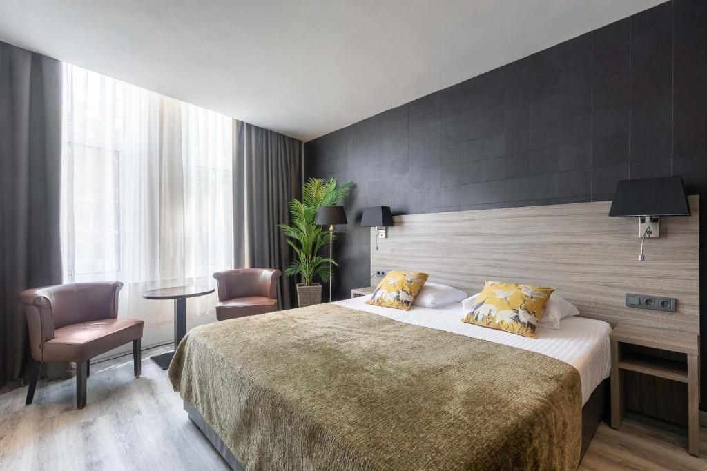 Comfortabele tweepersoonskamer in Hotel Milano, Rotterdam, vakantieappartement met stijlvolle inrichting en veel daglicht.