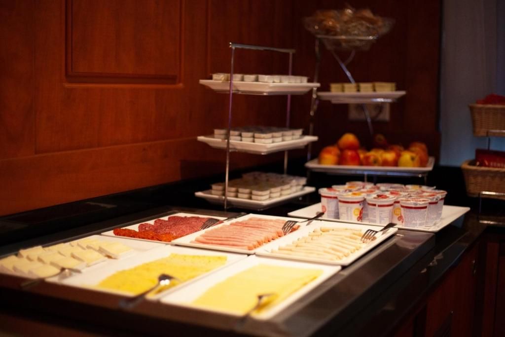 Ontbijtbuffet in Hotel Milano, vakantieappartement in Rotterdam, met diverse kazen, vleeswaren en fruit.