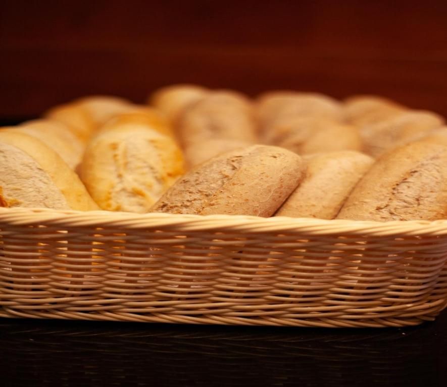 Mand met vers gebakken broodjes in Hotel Milano, vakantieappartement in Rotterdam, perfect voor ontbijt.