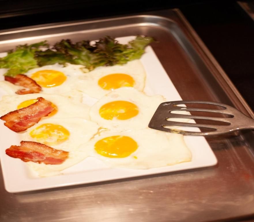 Gebakken eieren en spek geserveerd in Hotel Milano, vakantieappartement in Rotterdam, voor een stevig ontbijt.