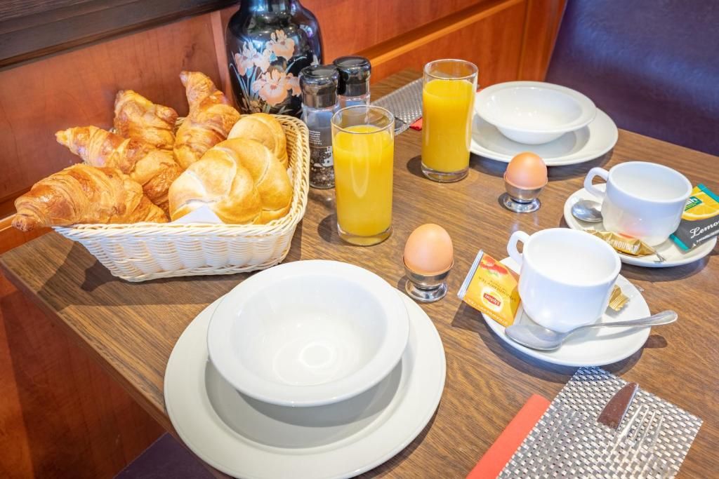 Ontbijttafel in Hotel Milano, vakantieappartement in Rotterdam, met verse croissants en sinaasappelsap.
