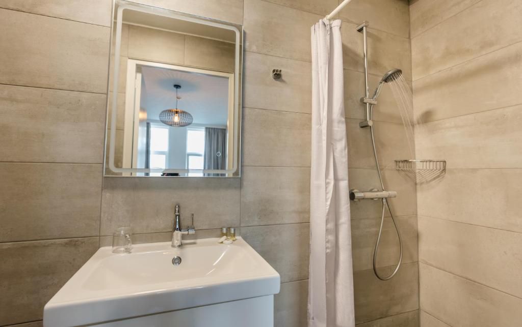 Modernes Badezimmer im Hotel Orion, Ferienwohnung in Rotterdam, Suedholland mit Dusche und Waschbecken.