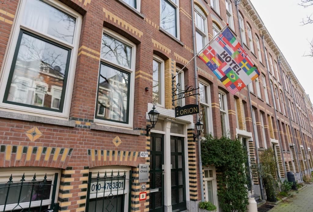 Aussenansicht des Hotels Orion, Ferienwohnung in Rotterdam, Suedholland, mit Fahnen und Backsteinfassade.