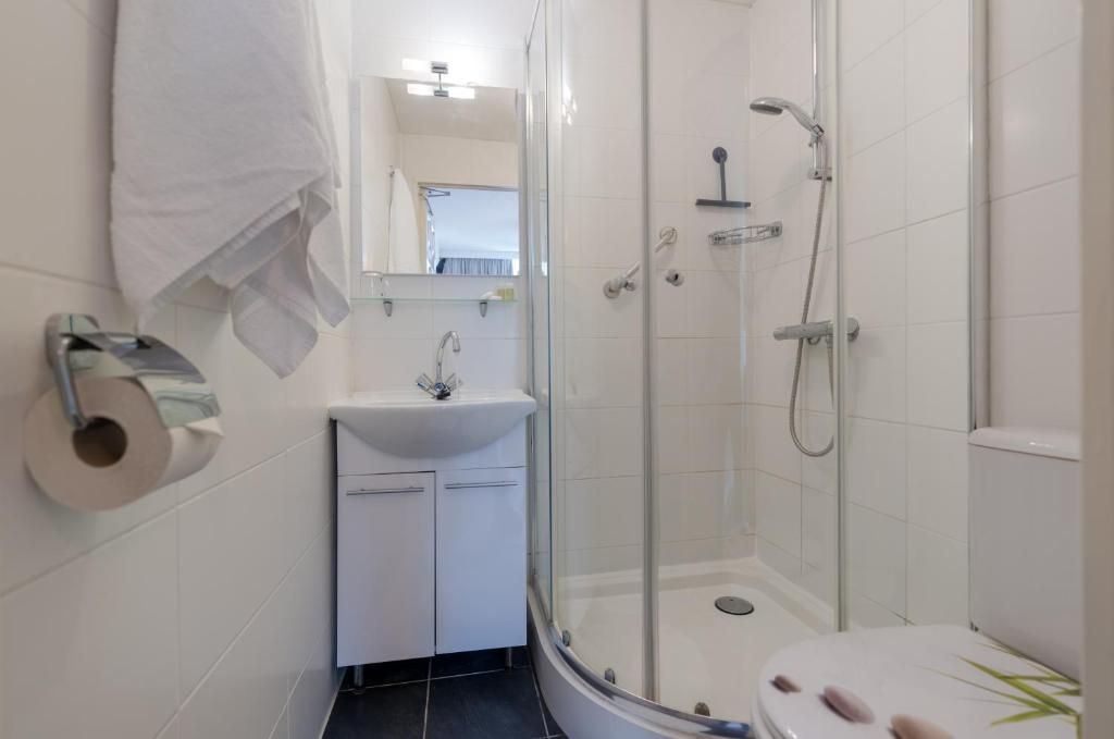 Kompaktes Badezimmer im Hotel Orion, Ferienwohnung in Rotterdam, Suedholland mit Duschkabine.