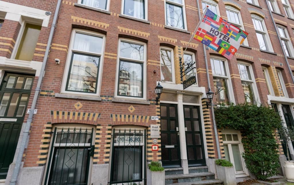 Eingang zum Hotel Orion, Ferienwohnung in Rotterdam, Suedholland mit internationalen Flaggen.
