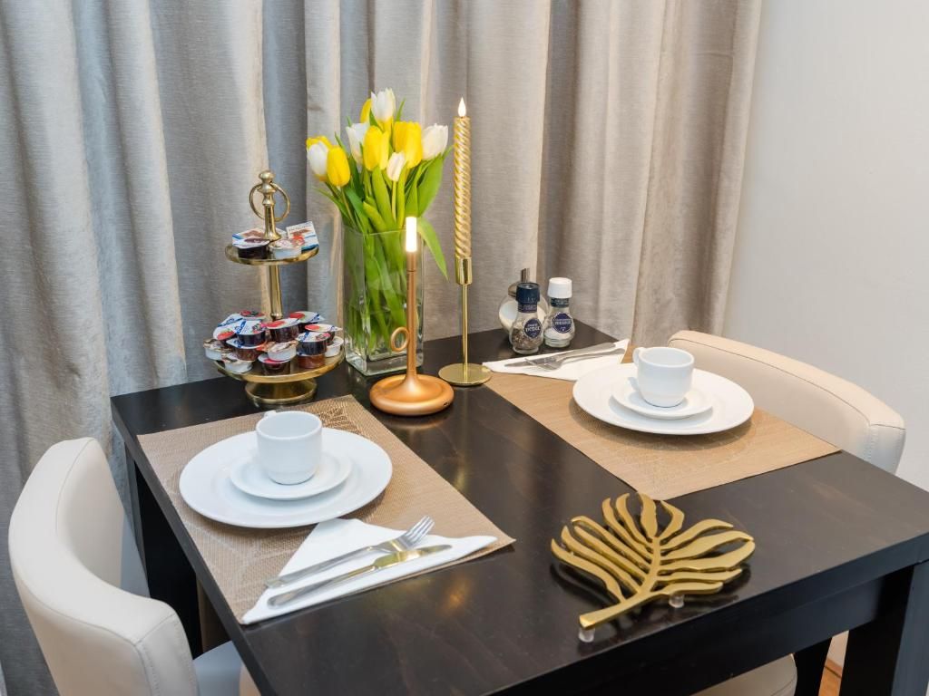 Elegant gedeckter Tisch im Hotel Orion, Ferienwohnung in Rotterdam, Suedholland mit Blumen.