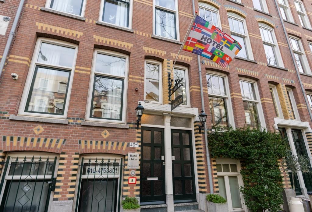 Charakteristische Fassade des Hotels Orion, Ferienwohnung in Rotterdam, Suedholland mit Flagge.