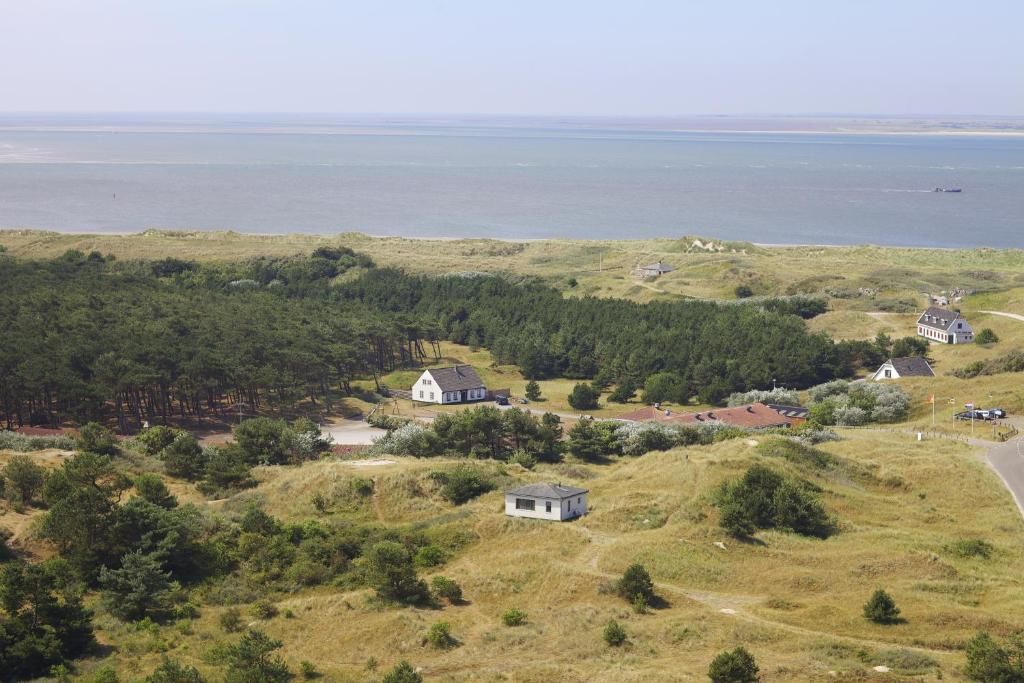 Aerial view of Sier aan Zee vacation home in Hollum, Ameland, surrounded by dunes and sea views.