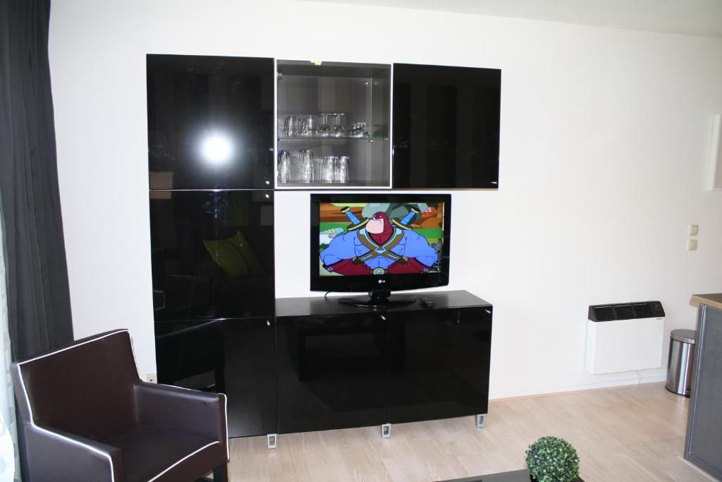 Woonkamer van Appartement HELIOS - Amelander Kaap met ZWEMBAD, Hollum, Ameland, met stijlvolle inrichting en entertainmentopties.