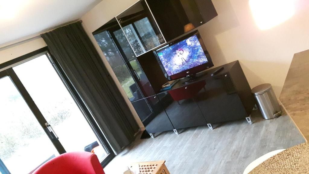 Moderne woonkamer met televisie in Appartement HELIOS - Amelander Kaap met ZWEMBAD, Hollum, Ameland, voor ontspanning.