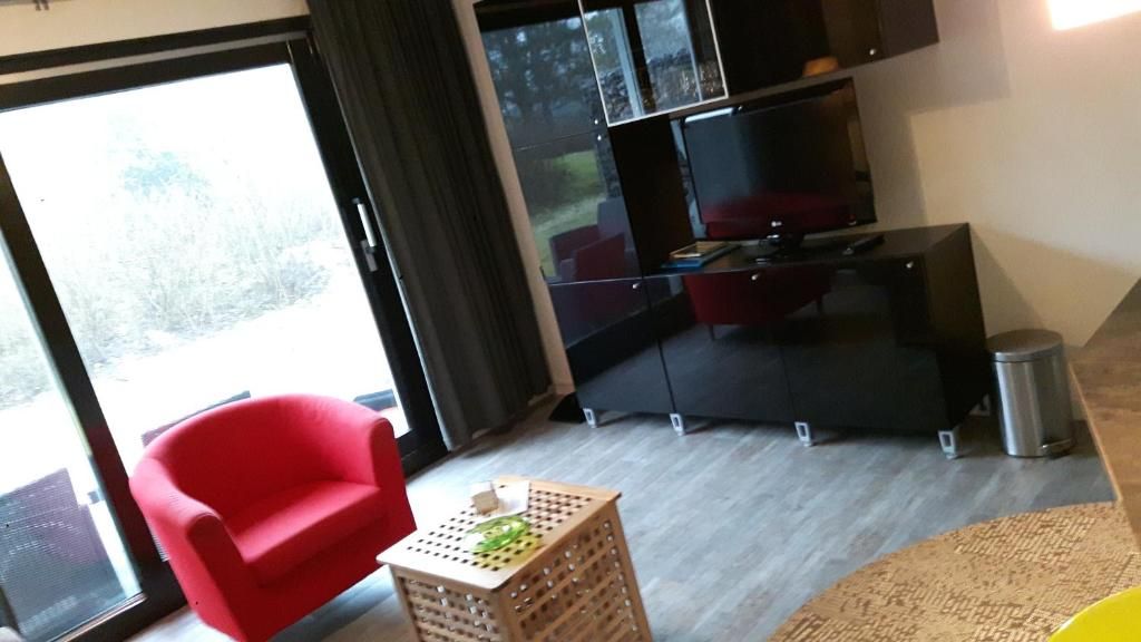 Stijlvolle woonkamer in Appartement HELIOS - Amelander Kaap met ZWEMBAD, Hollum, Ameland, met moderne meubels en uitzicht.