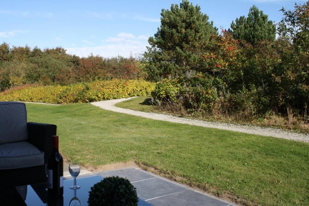 Uitzicht vanaf het terras van Appartement HELIOS - Amelander Kaap met ZWEMBAD, Hollum, Ameland, met groene natuur.