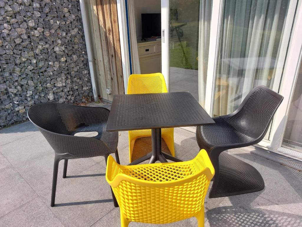 Outdoor terrace of Apartment Amelander-Kaap TIME-OUT with SWIMMING POOL, Hollum, Ameland, with colorful chairs.